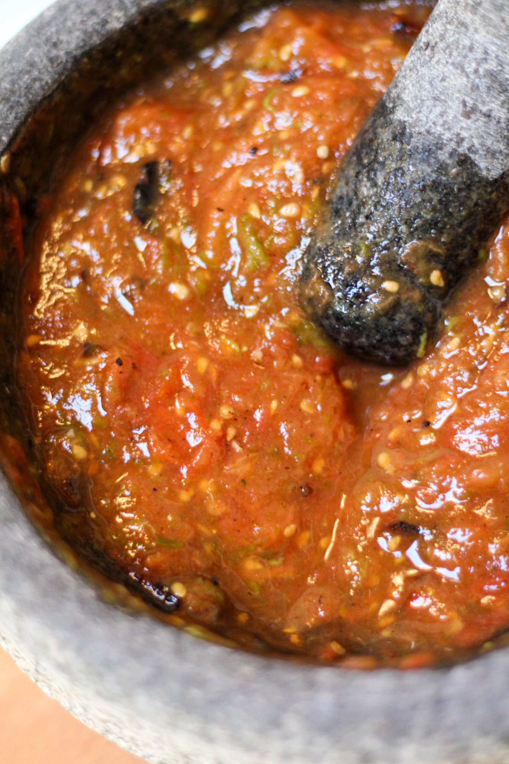 Authentic Mexican Salsa de Molcajete. Roasted tomato salsa in a mortar and pestle with cilantro