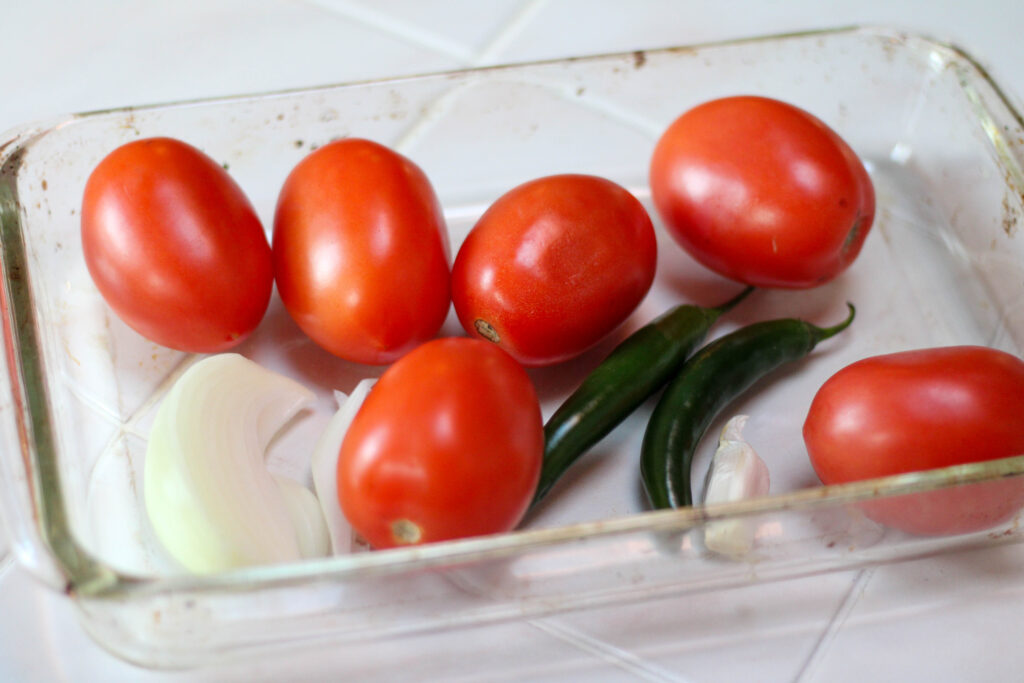 Tomatoes, serrano peppers, onion and garlic in a pyrex dish