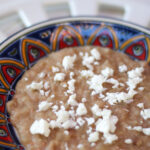 frijoles refritos topped with cheese on a plate