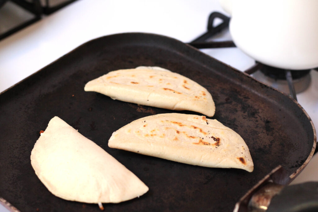 Quesadillas de Masa made by hand cooking on a comal.