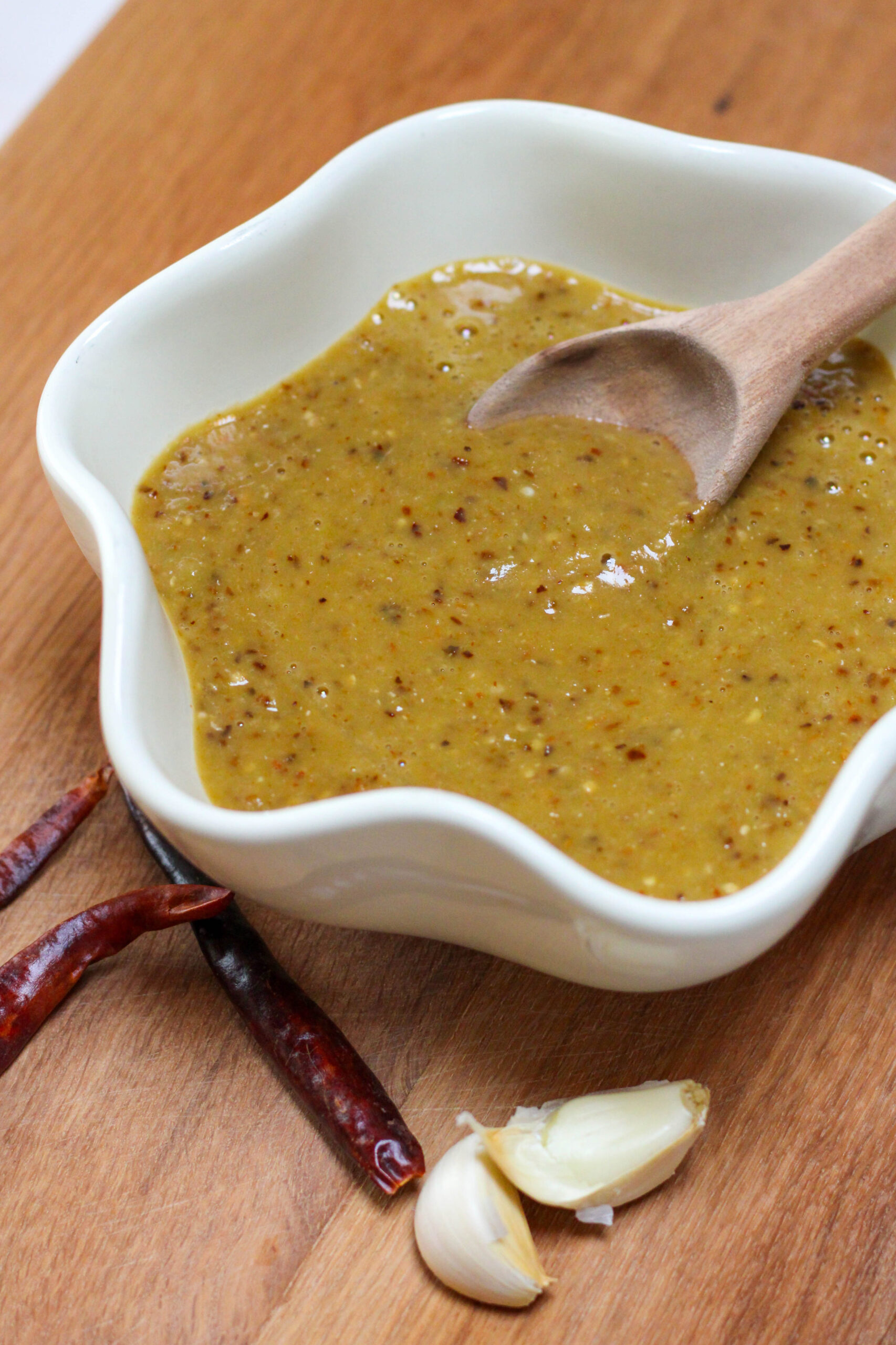 Salsa de chile árbol in a white bowl with wooden spoon. Easy and spicy salsa for tacos in a bowl with chile de árbol. 