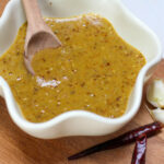 Salsa de chile árbol in a white bowl with wooden spoon. Easy and spicy salsa for tacos in a bowl with chile de árbol.