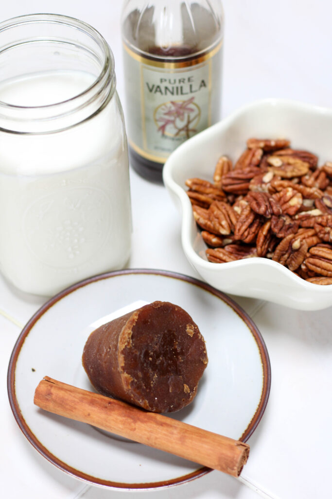 Ingredients for Atole de Nuez including piloncillo, cinnamon, pecans, milk and vanilla.