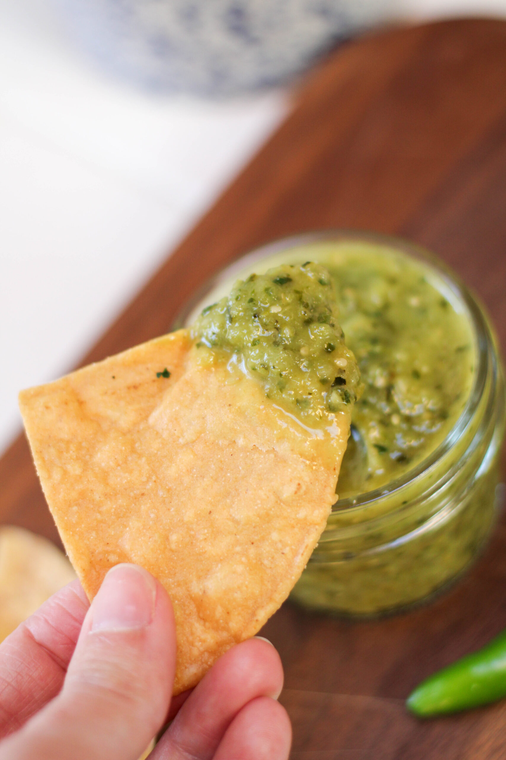 Hand holding chip dipped in Salsa de calabaza.