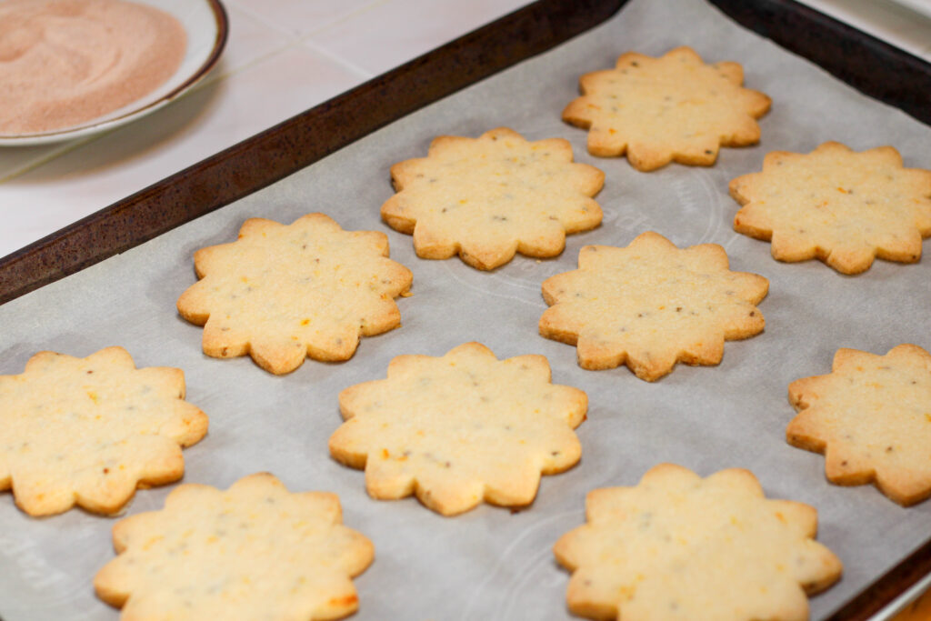 Bizcochitos on a cookie sheet without coating.