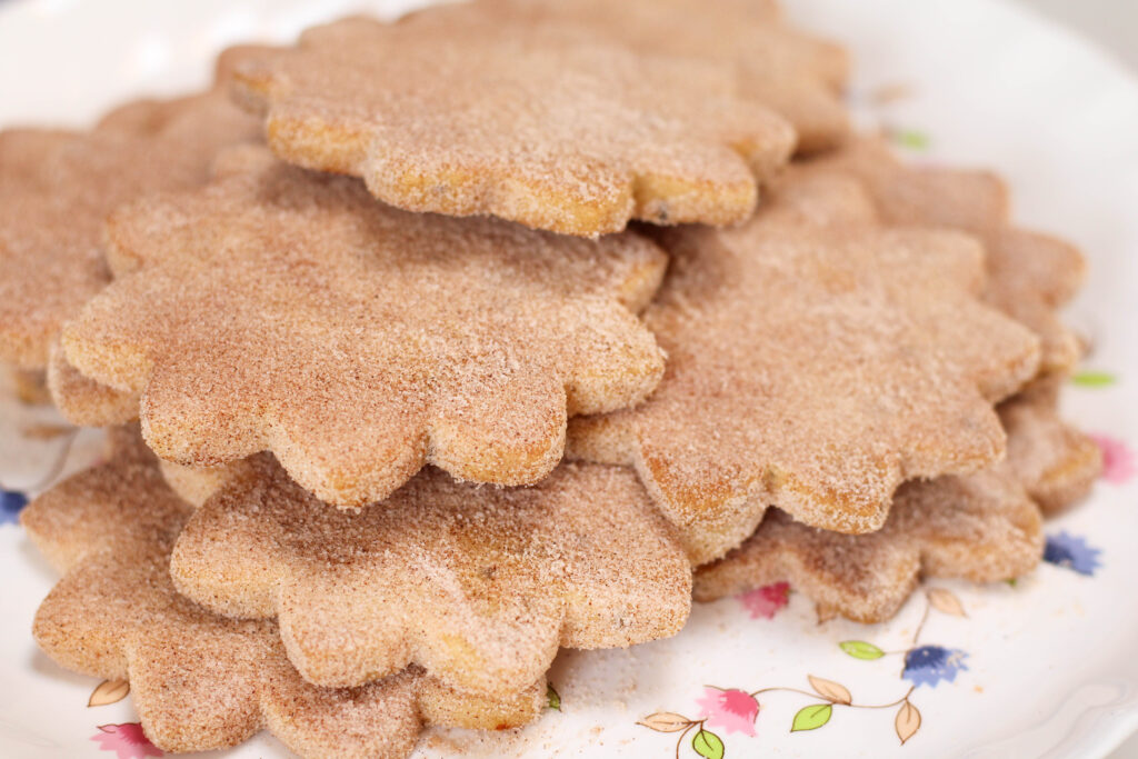 Bizcochitos in a star shape on a white platter.