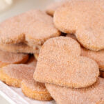 Heart shaped bizcochito cookies on a white platter.