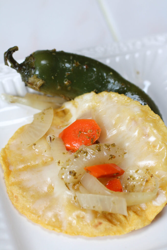 quesadilla with pickled carrots, onions and jalapenos on a white plate