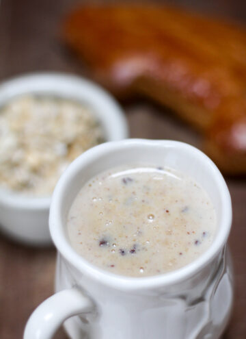white mug filled with atole de avena with brown background