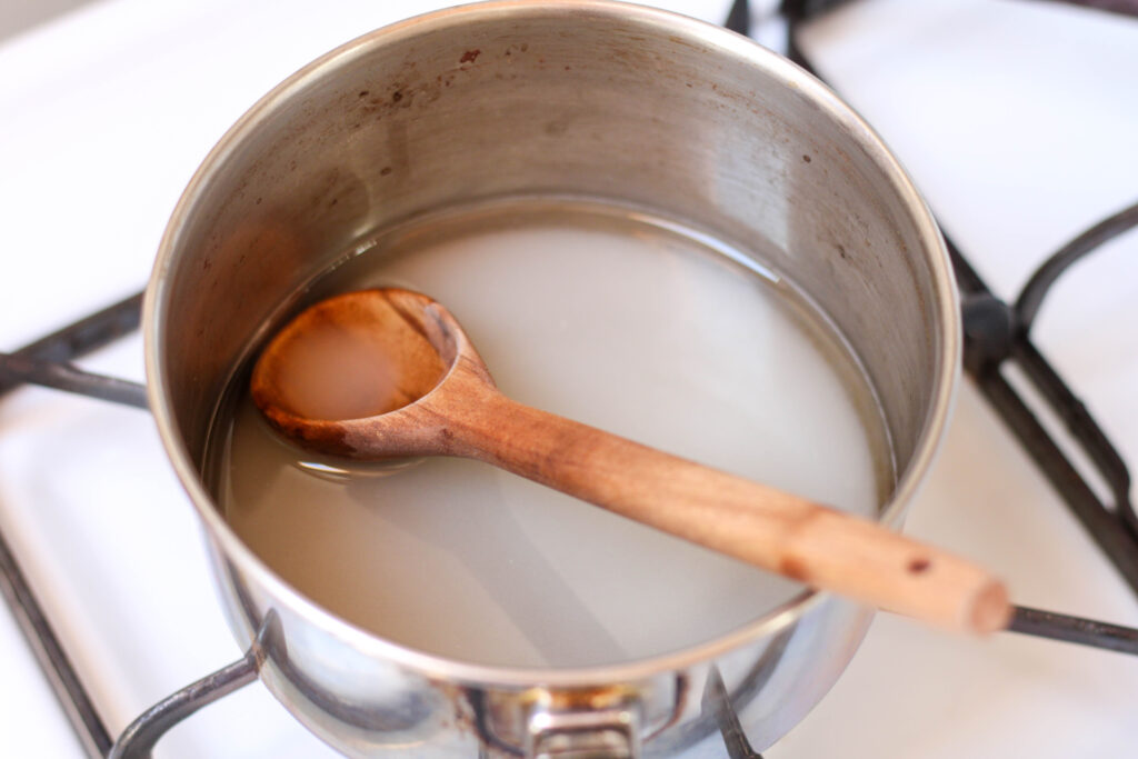 saucepan filled with water and sugar on the stove to make simple syrup