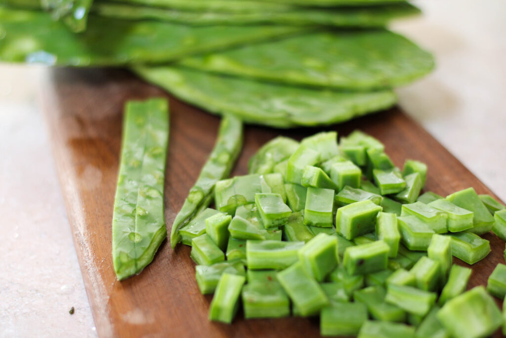 Nopales or cactus pads diced on a wood cutting board