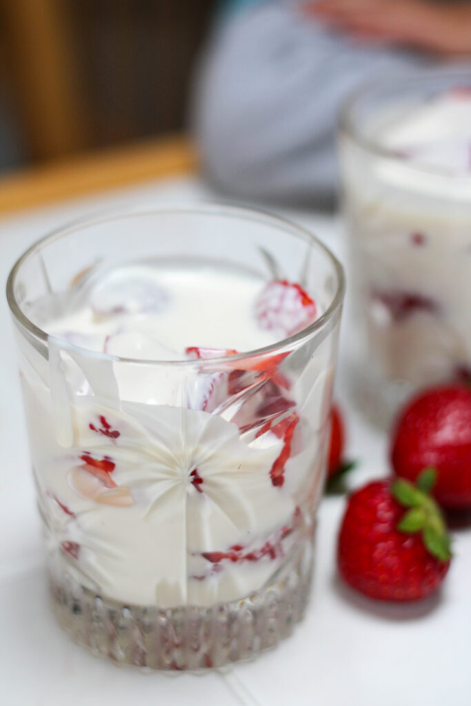 Fresas con crema in a short glass on a white table