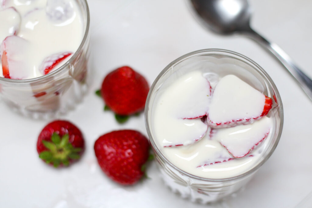 Fresas con crema in a short glass on a white table