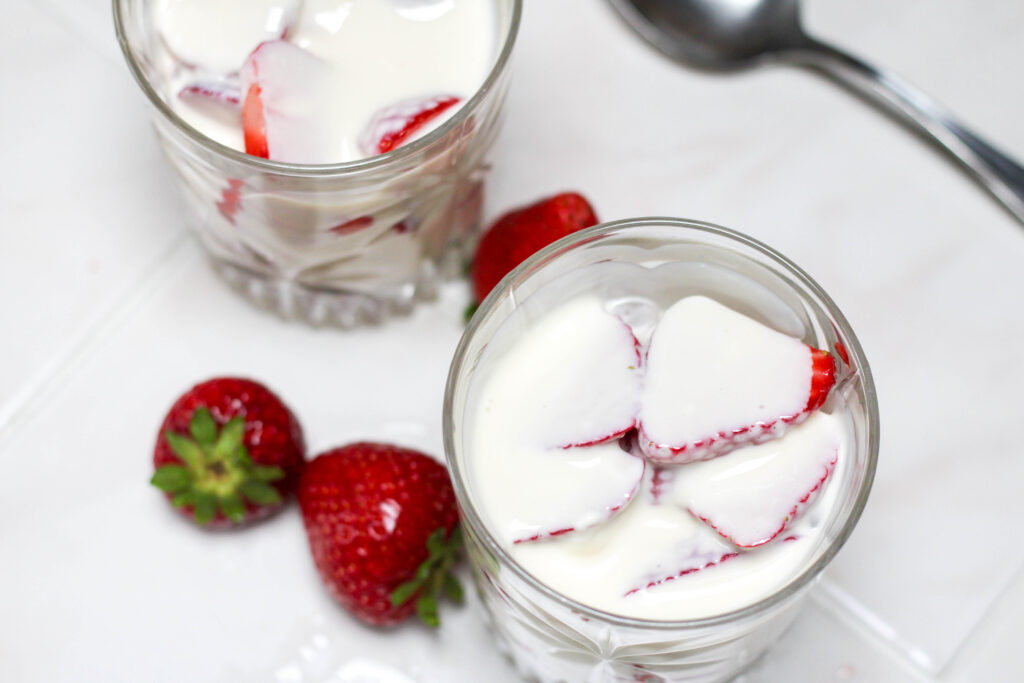 Fresas con crema in a short glass on a white table