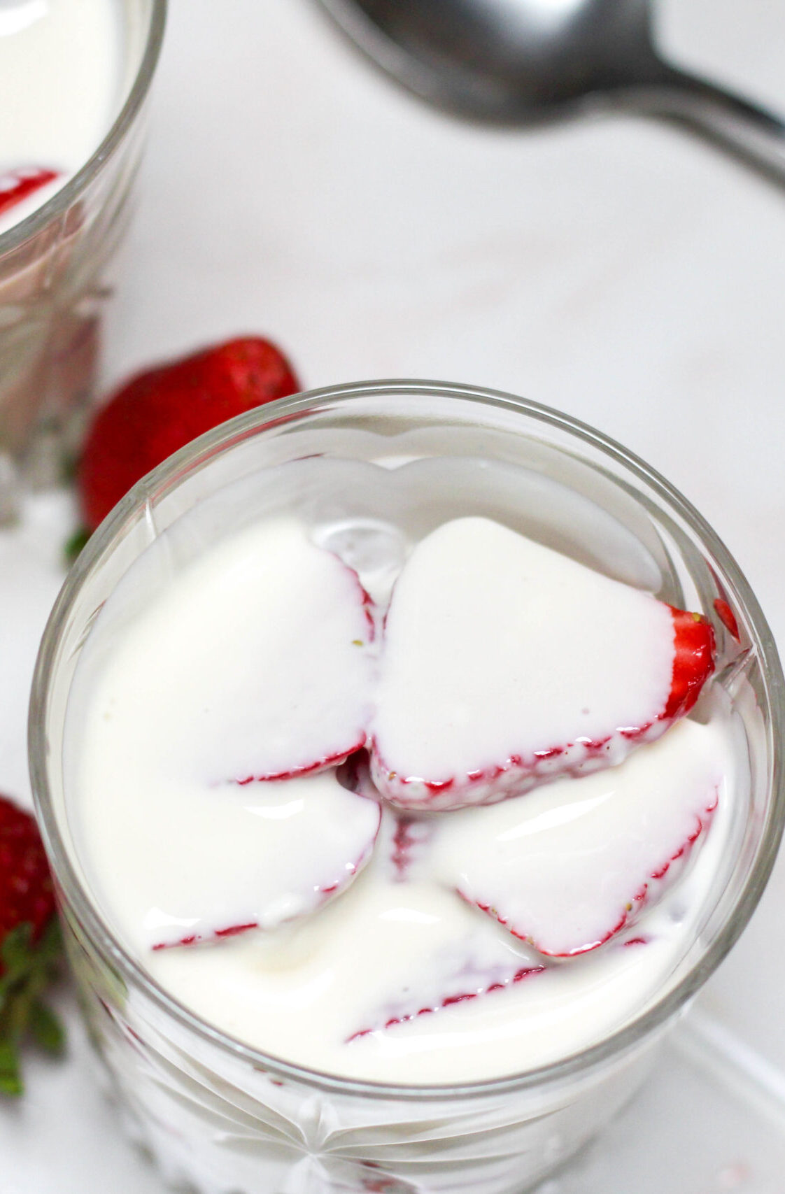 Fresas con crema in a short glass on a white table