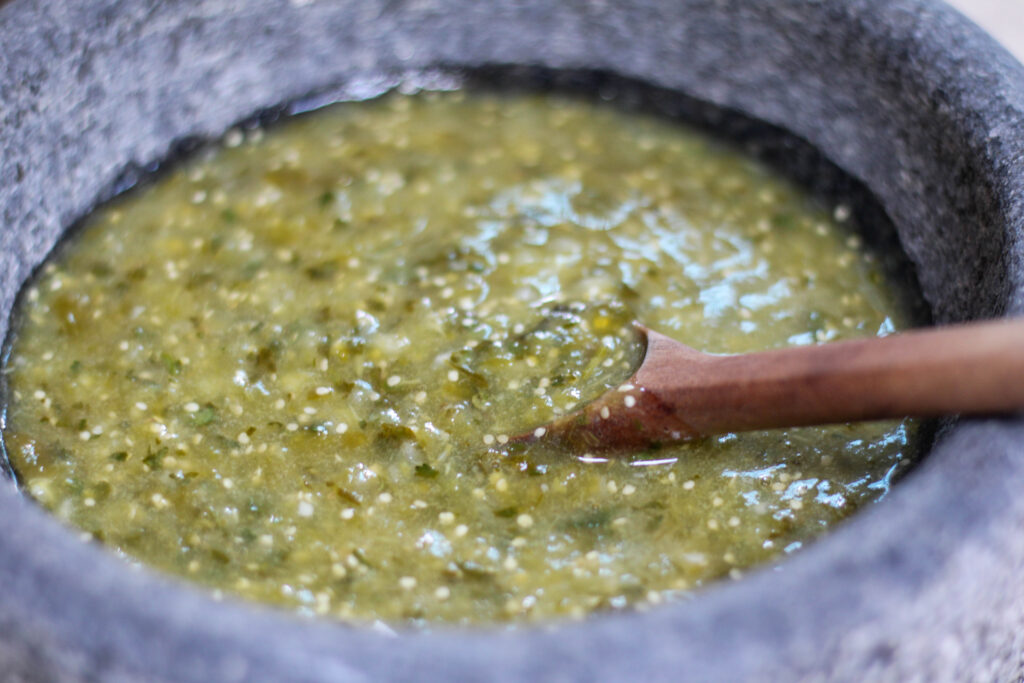 Salsa verde in a bowl with wooden spoon