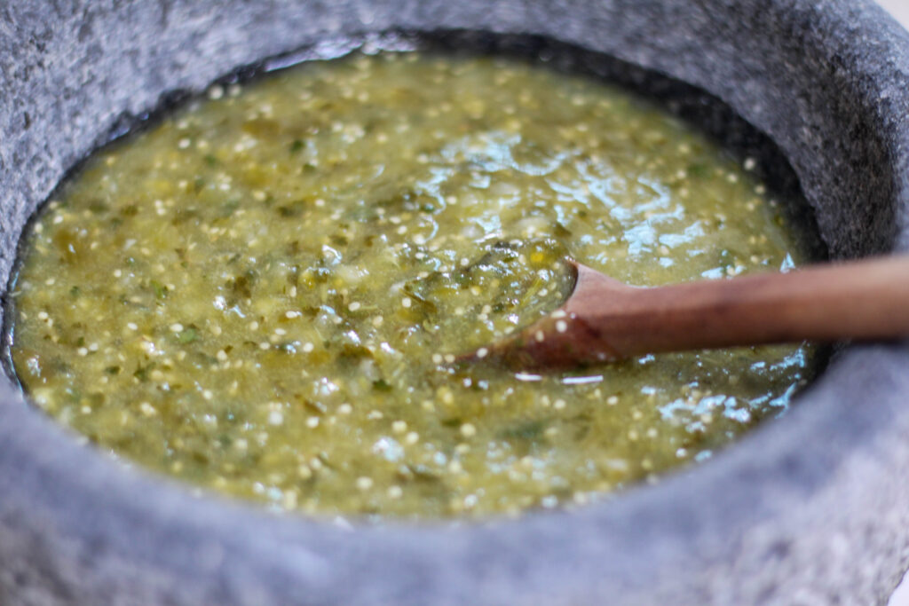 Salsa verde in a bowl with wooden spoon