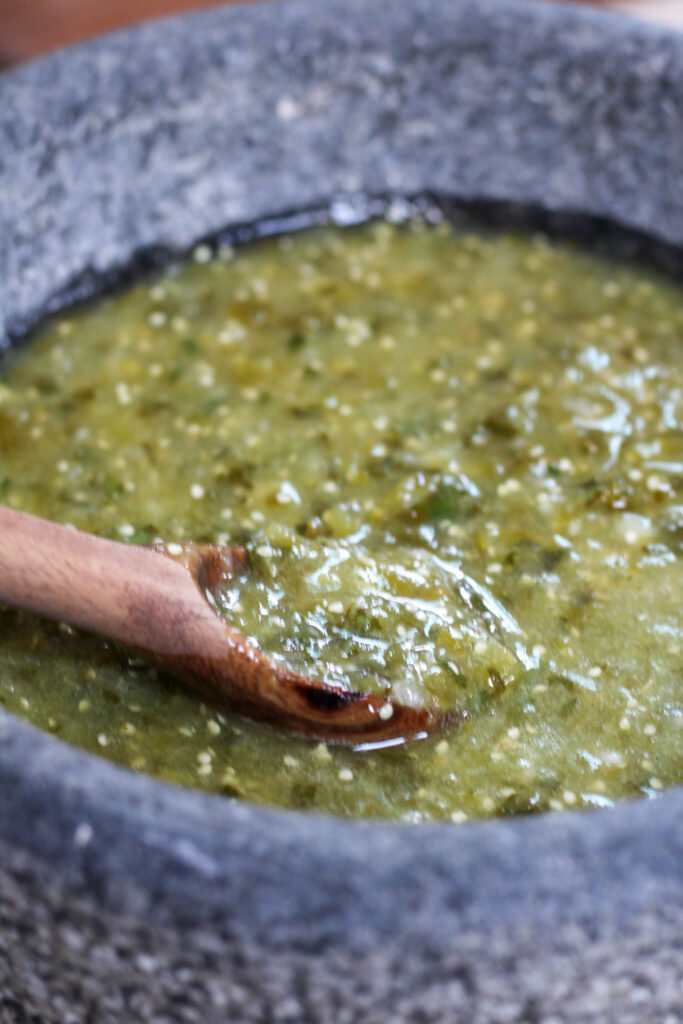 Salsa verde in a molcajete or mortar with wooden spoon