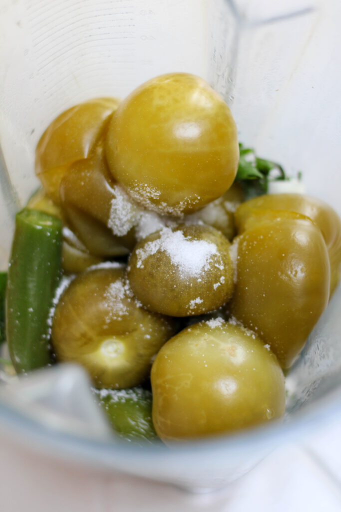 Tomatillos, serrano peppers and salt in a blender cup